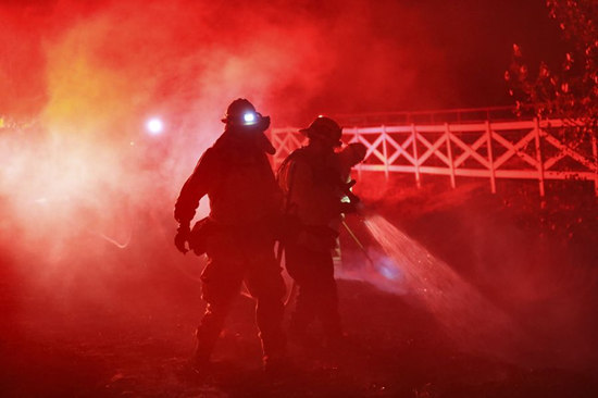 Firefighters work at a fire spot in Santa Clarita, the U.S. state of California, Oct. 24, 2019. (Xinhua/Li Ying)