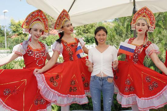 Performers pose for photos with a visitor during the 