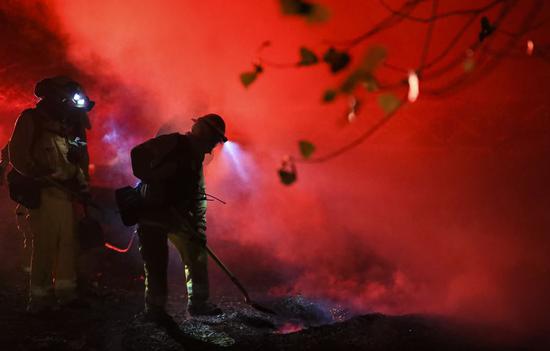 Firefighters work at a fire spot in Santa Clarita, the U.S. state of California, Oct. 24, 2019. (Xinhua/Li Ying)