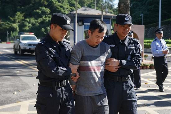 Hoang Minh Thong, a fugitive suspected of smuggling drugs, is escorted by police officers in south China's Guangxi Zhuang Autonomous Region, on Oct. 29, 2019. (Xinhua/Hu Jiali)