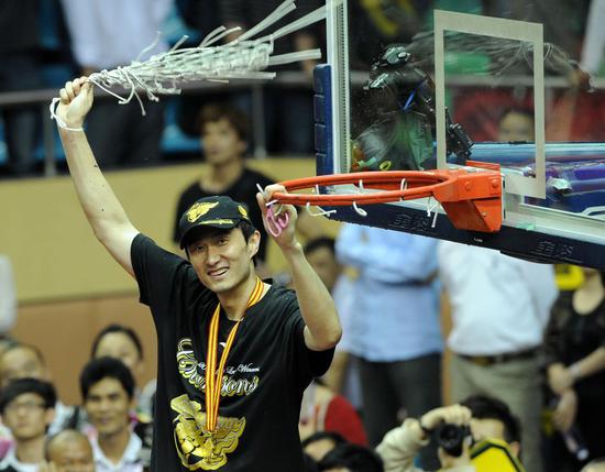 Du Feng, then a member of the CBA champions Guangdong Hongyuan team, holds up the net during the awarding ceremony of the 2009-2010 Chinese Basketball Association League (CBA) in Dongguan, south China on April 25, 2010. (Xinhua/Lu Hanxin)