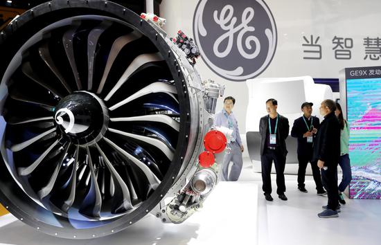 Visitors look at a model of GE's aircraft engine displayed at the first China International Import Expo in Shanghai, east China, Nov. 5, 2018. (Xinhua/Fang Zhe)