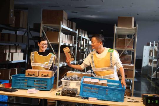Jack Ma (right), founder of Alibaba Group, works together with a logistics employee at a Cainiao Post in Hangzhou, Zhejiang Province. (Photo by Niu Jing/For China Daily)