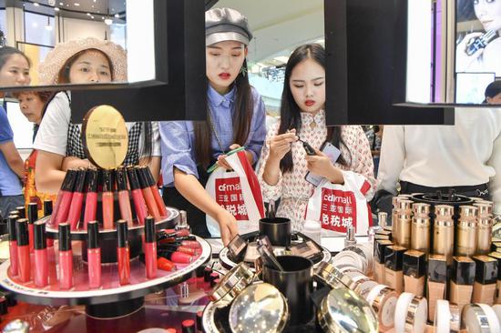 Customers check out cosmetics at a duty-free shop in Sanya, Hainan province. [Photo/China News Service]