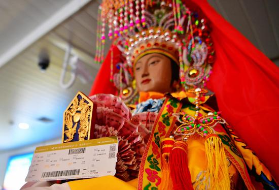 The goddess statue and her boarding pass (Xinhua/Wei Peiquan)