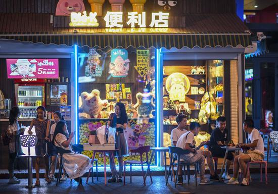 People have a rest in front of a convenience store in Urumqi, northwest China's Xinjiang Uygur Autonomous Region, July 14, 2019. (Xinhua/Zhao Ge)
