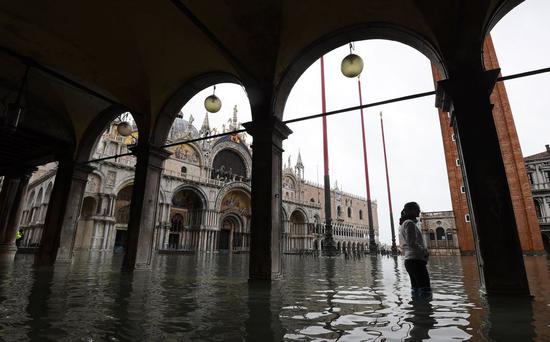 A woman wades through the flood in Venice, Italy, Nov. 17, 2019. The Italian government declared a state of emergency in Venice, after the ancient lagoon city was severely flooded. (Xinhua/Elisa Lingria)