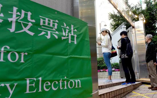 Photo taken on Nov. 24, 2019 shows electors in queue to cast ballots for the 2019 District Council Ordinary Election of the Hong Kong Special Administrative Region, China. (Photo/Xinhua)