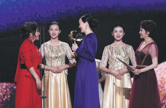 Yong Mei, lead actress in So Long, My Son, (wearing blue dress) is named best actress at the Golden Rooster Awards in Xiamen, Fujian province, on Saturday. (Photo/Xinhua)