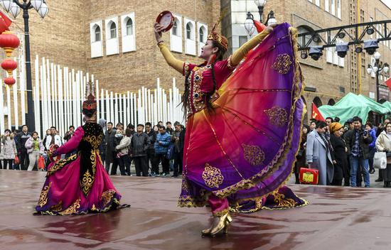 Tourists watch dancing performance at the Xinjiang International Grand Bazaar in Urumqi, northwest China's Xinjiang Uygur Autonomous Region, Nov. 7, 2019. (Xinhua/Wang Fei)
