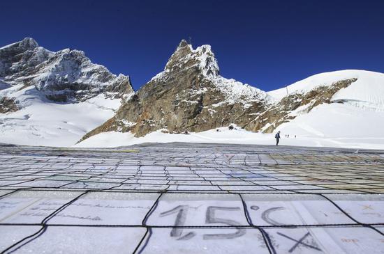 A gigantic postcard with the writing of 1.5 degrees Celsius is seen on the Aletsch glacier under Jungfraujoch in Switzerland, on Nov. 16, 2018. At the center of the postcard was a huge slogan reading 