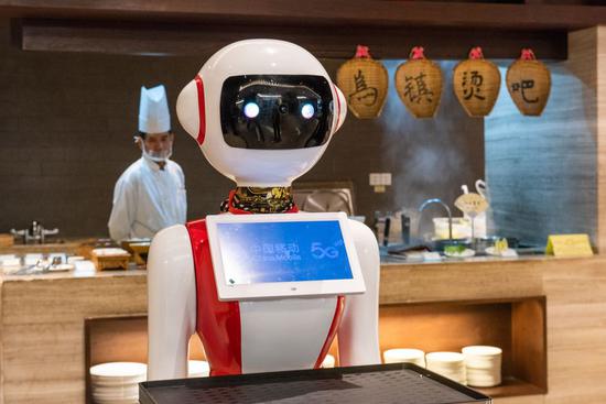 Photo taken on Oct. 19, 2019 shows a 5G-powered delivery robot in service, by which diners can order via the tablet, at a restaurant of Tong'an Hotel in Wuzhen, east China's Zhejiang Province. (Xinhua/Zhang Xiaoyu)