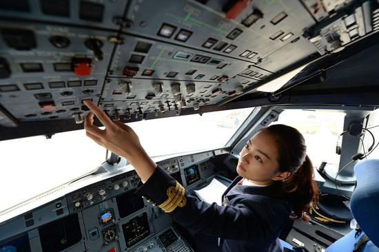 Female pilot Gu Xinyue examines an airplane cockpit before taking off in the cab in Hefei, east China's Anhui Province, March 6, 2019. (Xinhua/Zhang Dagang)