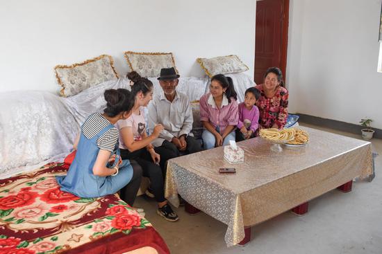 Residents chat at their new house in Yecheng County of Kashgar in northwest China's Xinjiang Uygur Autonomous Region, Aug. 19, 2019. (Xinhua/Ding Lei)