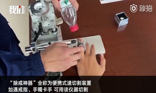 A firefighter from North China's Tianjin Municipality uses a device he invented that can cut metal objects that get stuck on a person's finger or wrist. (Photo/Screenshot from video by WeVideo)