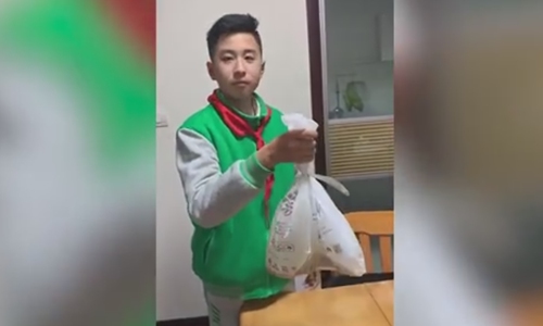 Shi Yuan, a middle school student from Shanghai displays a special waste bag invented from his idea. The special waste bag performs extremely well in preventing smelly odor and keeping people's hand clean. (Screenshot photo/Sina Weibo)