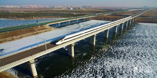 The G2405 Fuxing bullet train flashes by on Dec 11, during a test run on the high-speed railway linking Hohhot with Beijing, Dec. 11. (Photo/Inner Mongolia Daily)