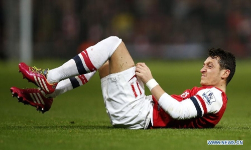 Mesut Özil of Arsenal reacts after being fouled during the Barclays Premier League match between Arsenal and Everton at Emirates Stadiumin London, Britain on Dec. 8, 2013. The match ended with a 1-1 draw. (Photo/Xinhua)