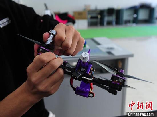 Wang Tielin does research about drone parts. (Photo/China News Service)