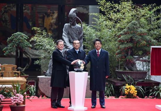 Chinese Premier Li Keqiang, President of the Republic of Korea (ROK) Moon Jae-in and Japanese Prime Minister Shinzo Abe attend a launching ceremony of a commemorative envelope marking the 20th anniversary of trilateral cooperation at the Du Fu Thatched Cottage Museum in Chengdu, southwest China's Sichuan Province, Dec. 24, 2019. (Xinhua/Zhang Ling)