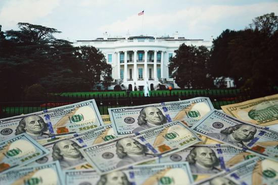 U.S. dollar banknotes and an image of White House are arranged for a photograph in Washington D.C., the United States, Aug. 20, 2019. (Xinhua/Liu Jie)