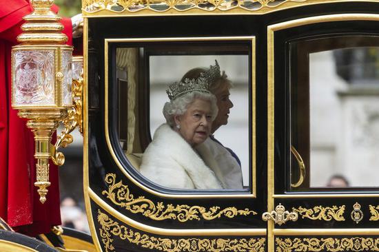 British Queen Elizabeth II travels by carriage along The Mall ahead of the State Opening of Parliament ceremony at the Palace of Westminster in London, Britain, Oct. 14, 2019. (Photo by Ray Tang/Xinhua)