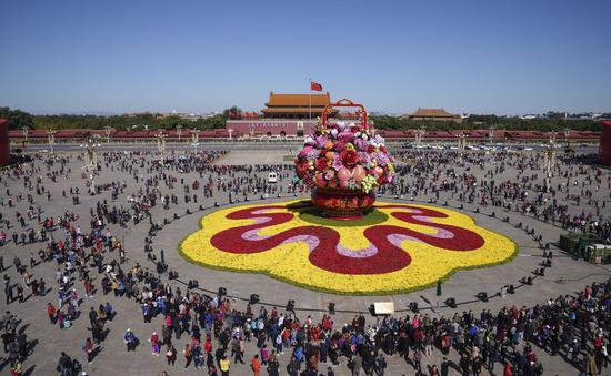 Tourists watch basket-shaped flower beds at Tiananmen Square in Beijing, China, October 14, 2019. (Xinhua/Yin Gang)