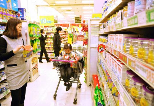 Consumers check out infant and toddler formulas at a supermarket in Qingdao, Shandong province. (Photo/China Daily)