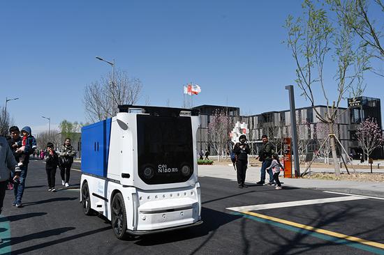 A Cainiao Network 's self-driving electric express car runs in Xiongan New Area in Baoding city, Hebei province. (Photo/Xinhua)