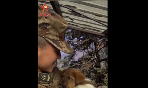 An isolated PLA soldier play with his poppy. (Photo/Screenshot of video posted on Sina Weibo)