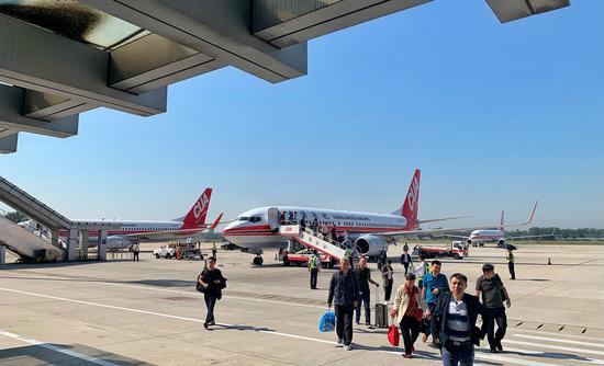 Passengers get off a plane at Nanyuan Airport in Beijing, capital of China, Sept. 25, 2019. (Xinhua/Li Xin)