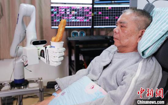 Zhang, who is completely paralyzed, moves a fried dough stick with his thoughts with the help of brain-computer interface. (Photo provided to China News Service)