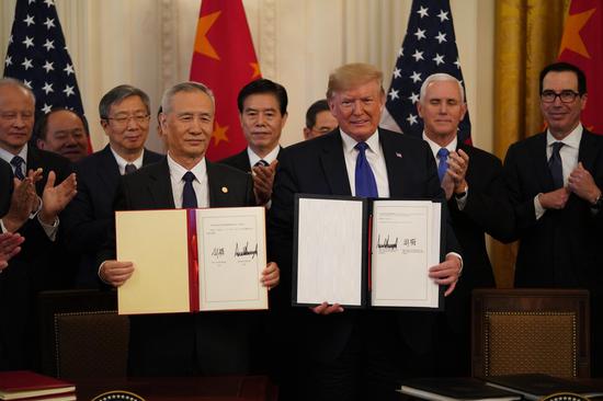 U.S. President Donald Trump and Chinese Vice Premier Liu He, who is also a member of the Political Bureau of the Communist Party of China Central Committee and chief of the Chinese side of the China-U.S. comprehensive economic dialogue, show the signed China-U.S. phase-one economic and trade agreement during a ceremony at the East Room of the White House in Washington D.C., the United States, Jan. 15, 2020. (Xinhua/Wang Ying)