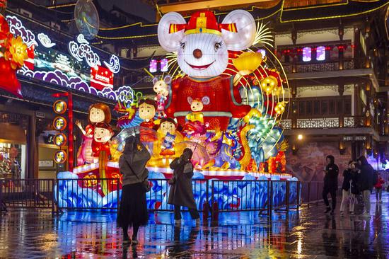 Tourists take photos in front of the main light group themed on the rat during the Yuyuan Spring Lantern Festival at the Yuyuan Garden in Shanghai, east China, Jan. 10, 2020. (Photo by Wang Xiang/Xinhua)
