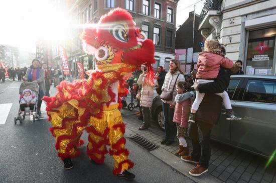A lion dance performer interacts with the audience during a Chinese Spring Festival parade in downtown Liege, Belgium, Jan. 18, 2020. (Xinhua/Zheng Huansong)