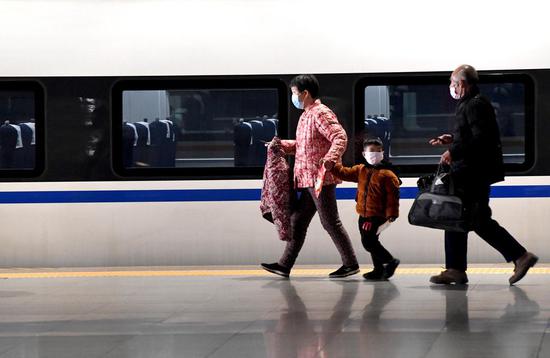 Passengers wearing masks prepare to board a train at Zhengzhou East Railway Station in Zhengzhou, central China's Henan Province, Feb. 1, 2020. (Xinhua/Li An)