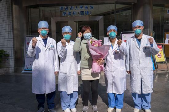 A cured patient (C) poses for a group photo with medical staff in front of a hospital in Qingyuan, south China's Guangdong Province, Jan. 30, 2020. (Photo by Li Sijing/Xinhua)