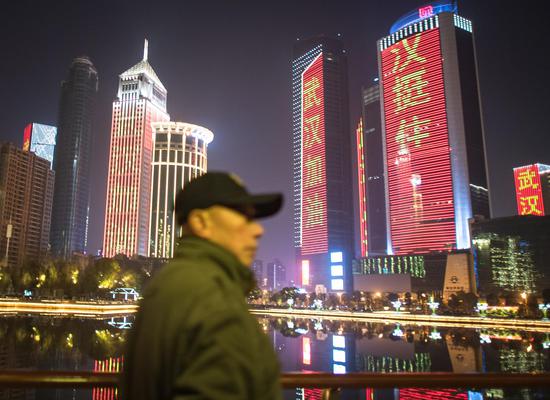 Photo taken on Jan. 31, 2020 shows buildings illuminated with slogans to cheer the city on in Wuhan, central China's Hubei Province. (Xinhua/Xiao Yijiu)