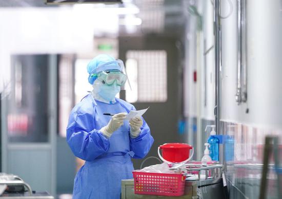 A nurse checks a patient's treatment list at the corridor of the isolation wards in Zhangzhou Municipal Hospital in Zhangzhou, southeast China's Fujian Province, Feb. 2, 2020. (Photo by Xiao Heyong/Xinhua)