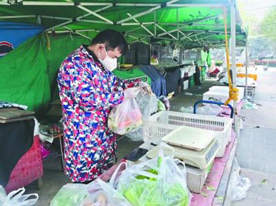 A supplier delivers vegetables at a community in Hankou, Wuhan City, Hubei Province. (Photo/Changjiang Daily)