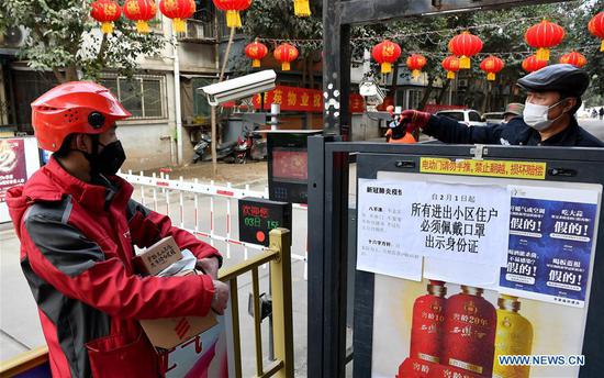 Xu Guobin enters a compound in Xi'an, northwest China's Shaanxi Province, Feb. 3, 2020. Deliveryman Xu Guobin has continued to work during the Spring Festival holidays for straight 12 days. Influenced by the outbreak of novel coronavirus, Xu has to deliver packages three times more than the last years. When asked if he was worried about being infected, Xu responded by saying that although he had such concern, what he could do was to well protect himself while delivering packages to the people who needed them. (Xinhua/Liu Xiao)