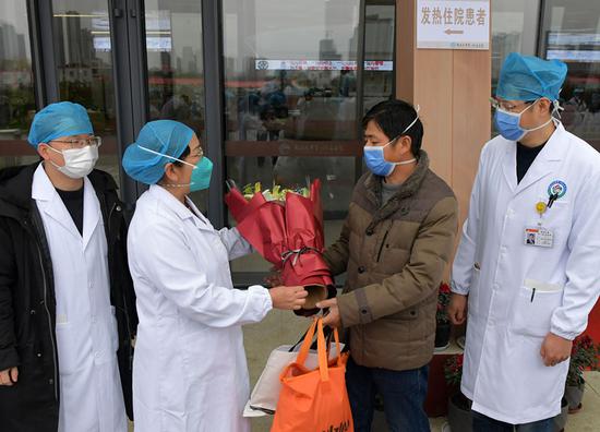 A medical staff member gives flowers to a patient to congratulate his cure at the First Affiliated Hospital of Nanchang University in Nanchang, east China's Jiangxi Province, Jan. 27, 2020. (Xinhua/Peng Zhaozhi)