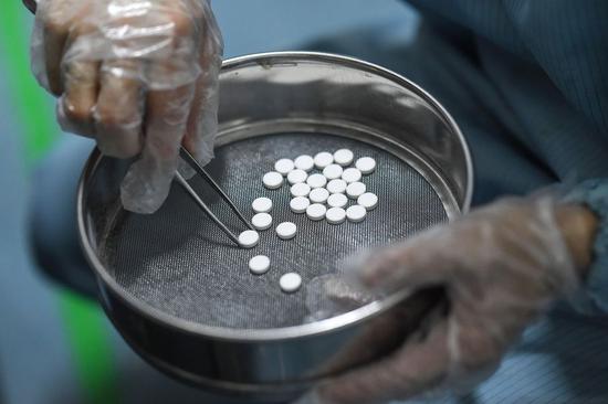 A worker weighs drugs at the workshop of a pharmaceutical company in Haikou, south China's Hainan Province, Feb. 3, 2020. The workshop of a pharmaceutical company in Haikou has been working round the clock since Jan. 20 to ensure the supply of drugs during the fight against novel coronavirus outbreak. (Photo by Pu Xiaoxu/Xinhua)