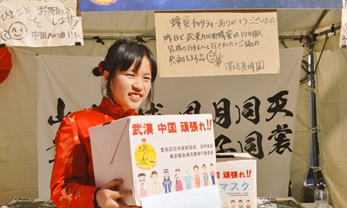 A Japanese girl, 14, raises donations for China’s Wuhan, epicenter of the coronavirus outbreak, at a festival in Tokyo on Sunday. (Photo/huanqiu.com)