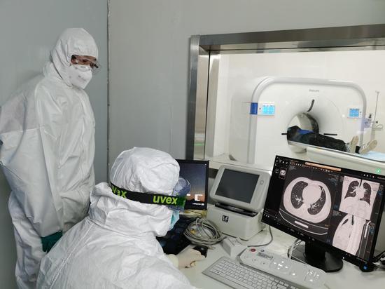 Doctors check the CT image of a patient's lungs at Leishenshan (Thunder God Mountain) Hospital in Wuhan, capital of central China's Hubei Province, Feb. 9, 2020. (Photo by Gao Xiang/Xinhua)