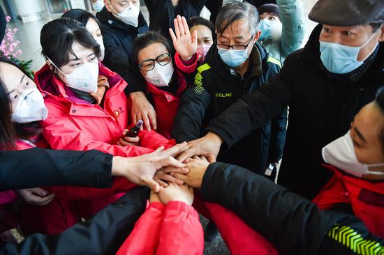 Members of the fourth medical team of Shanxi and their colleagues cheer for each other before leaving for Hubei Province at Wusu International Airport in Taiyuan, capital of north China's Shanxi Province, Feb. 9, 2020. (Xinhua/Chai Ting)