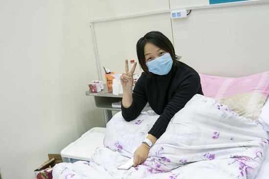 A patient poses for photos at a temporary hospital converted from 
