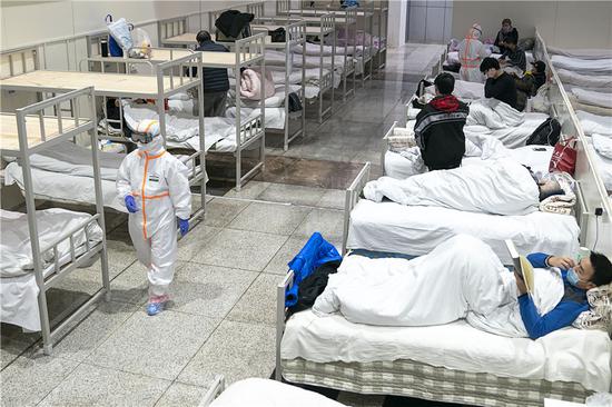 Photo of a male patient who was spotted reading a book in one of the makeshift hospitals in Wuhan gone viral on Chinese social media. /Photo via Hubei Daily