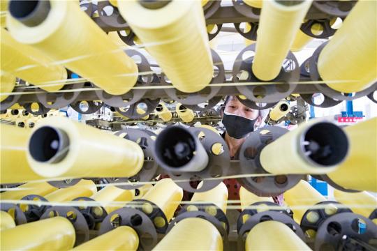 An employee checks production machinery at a factory in Hefei, Anhui province, on Monday after some companies resumed production.(Photo by Zhao Ming/For China Daily)