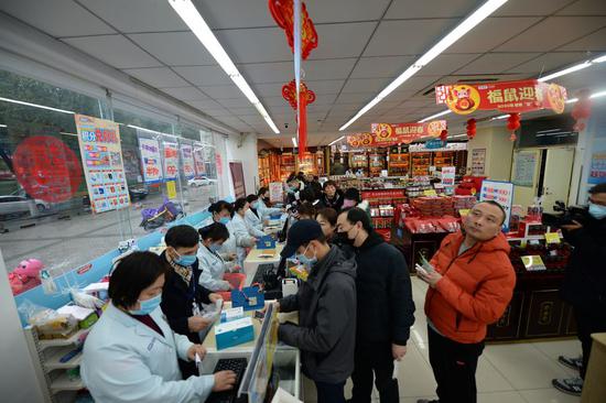 Citizens line up for masks at a drug store in Changsha, central China's Hunan Province, Jan. 23, 2020. (Photo by Chen Zhenhai/Xinhua)